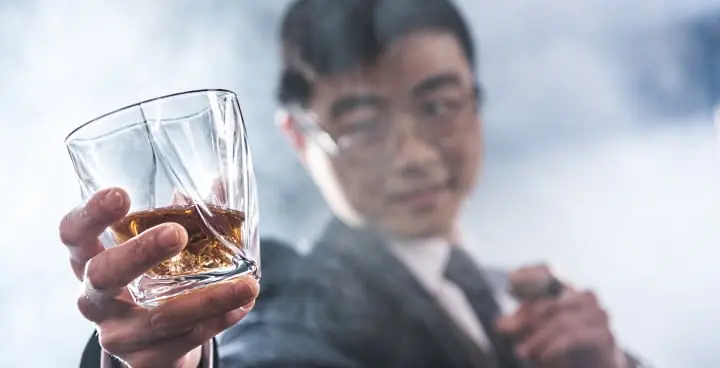 Japansk whisky - omslagsbild en japan håller ett glas whisky - Vinjournalen.se